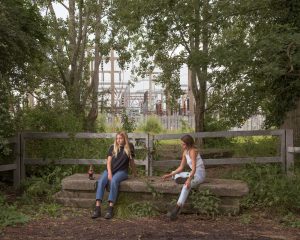 Image of two girls sitting on a stone bench