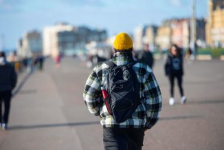 boy with backpack on brighton seafront