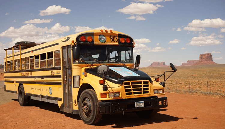 American school bus with monument valley Arizona in the background