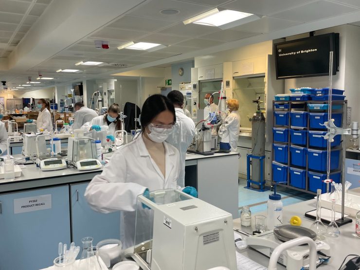 Female student carrying out an experiment in the lab using a box-like equipment