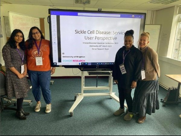 Group of students standing in front of a presentation about Sickle Cell Disease