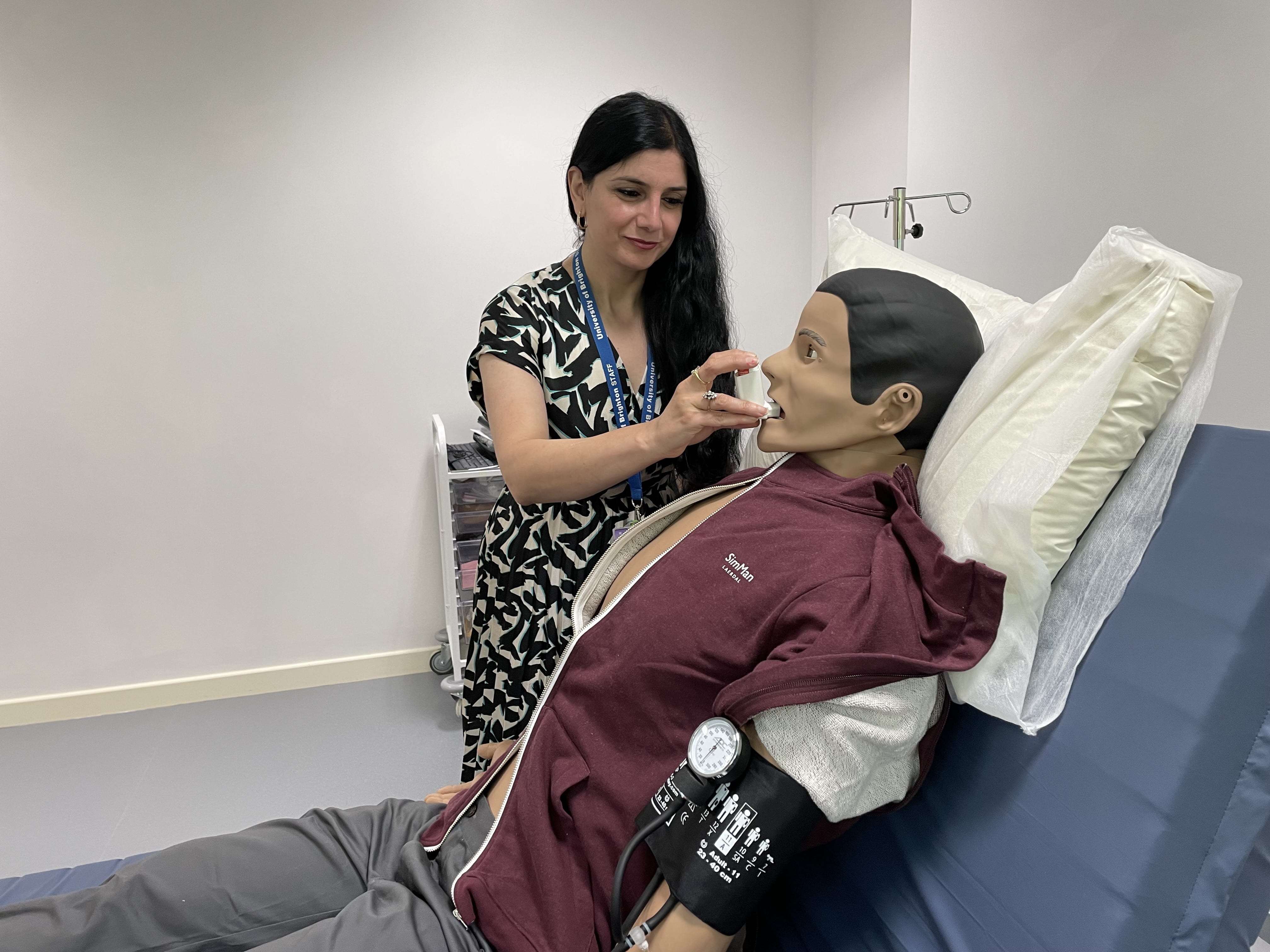 Safoora Azimi-Yancheshmeh administers asthma medication to one of the 'Sim' people
