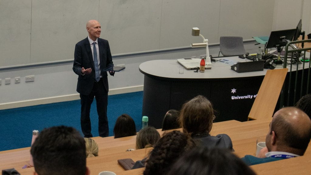 David Webb presenting in a lecture theatre filled with people 
