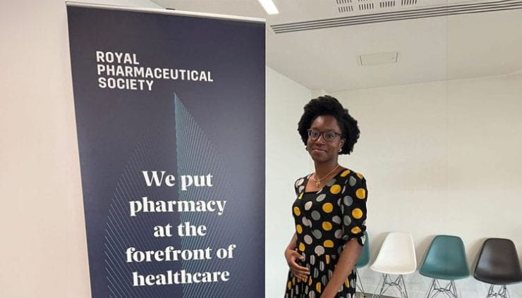 Grace-Oreyeni-standing-in-font-of-a-Royal-Pharmaceutical-Society-banner