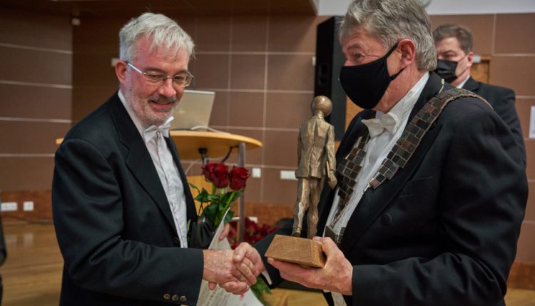 Photograph of award ceremony, Professor Chris Joyce shaking hands with presenter