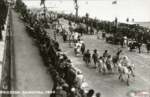 Black and white grainy image of a seafront procession with costumes and floats. Brighton in 1922.