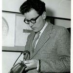 Black and white picture of Gerald Benney as a young man with thick rimmed glasses and checked jacket