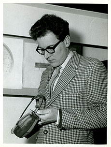Black and white picture of Gerald Benney as a young man with thick rimmed glasses and checked jacket