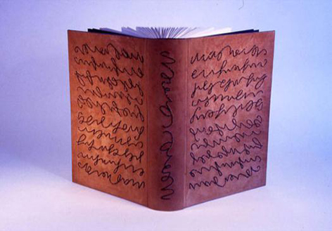 A book binding in dark red cloth with raised shapes like handwritten letter patterns