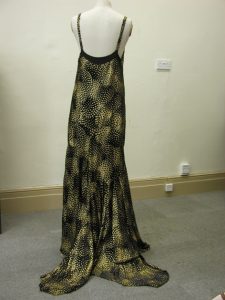 Long flowing slim dress in black and gold on display figure
