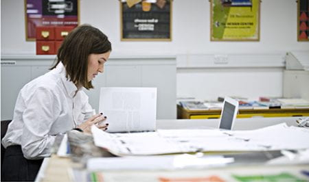 Colour photograph of Leah Armstrong doing research in the University of Brighton Design Archives