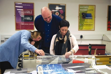 Colour photograph of designers looking through the Icograda Archive at the University of Brighton Design Archives 