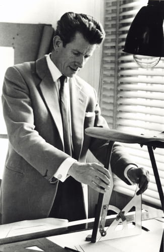 Black and white portrait of Robin Day measuring a chair leg angle