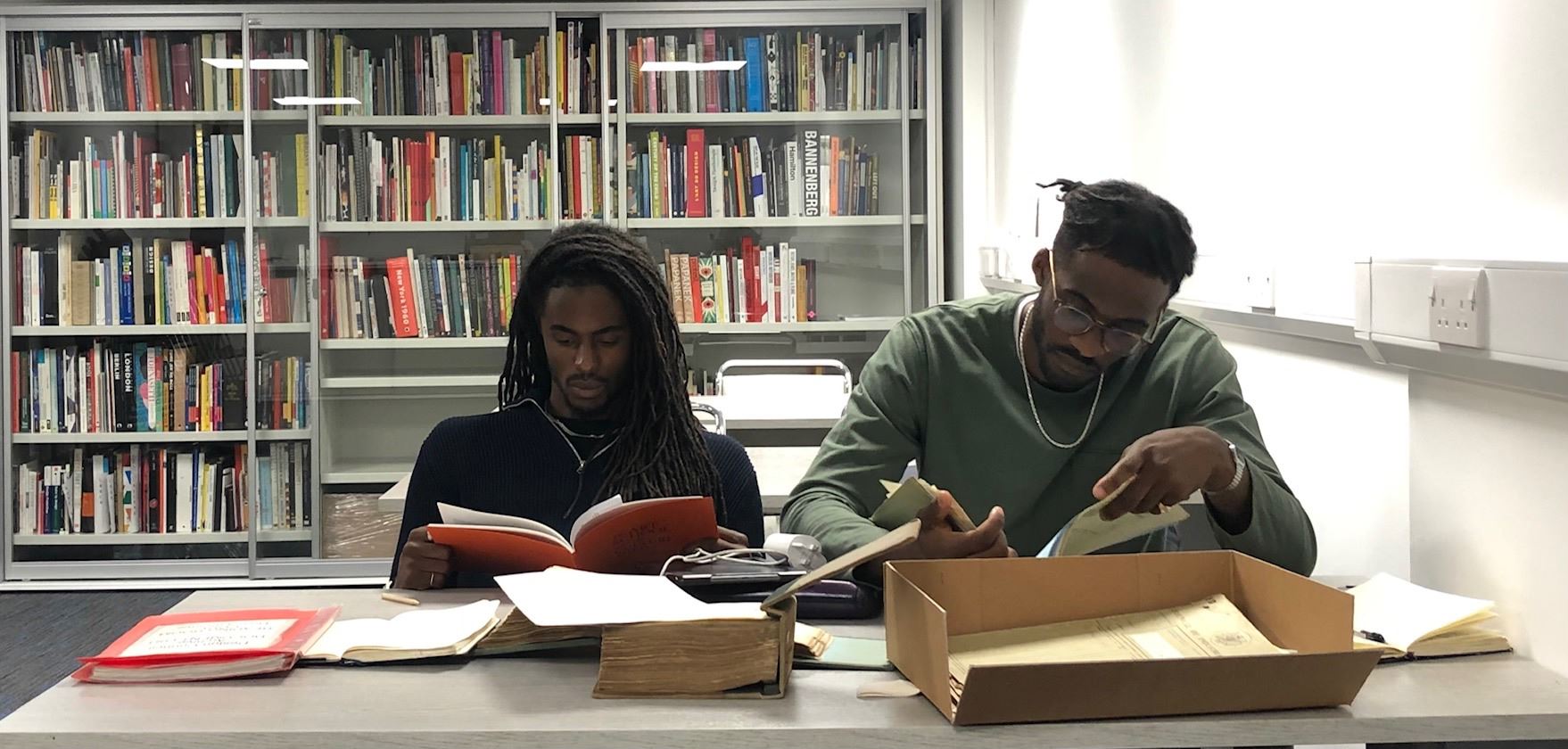 Two members of the Resolve Collective researching archival materials in reading room
