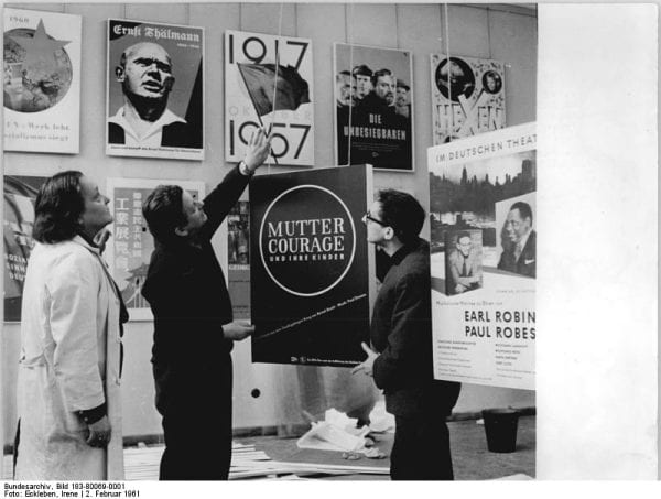 Two people holding design posters at an exhibition in Berlin