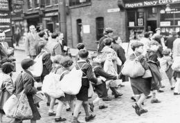 Black and white image of evacuated school children walking to a railway station