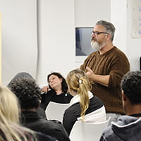 Man standing in a workshop group sharing iniitial thoughts on a story prompt
