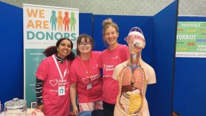 Nadeen, Estella and Lois at University of Brighton Falmer Campus Freshers' Fair! They are all wearing pink NHSBT t-shirts and are posing with a human torso with its organs showing.