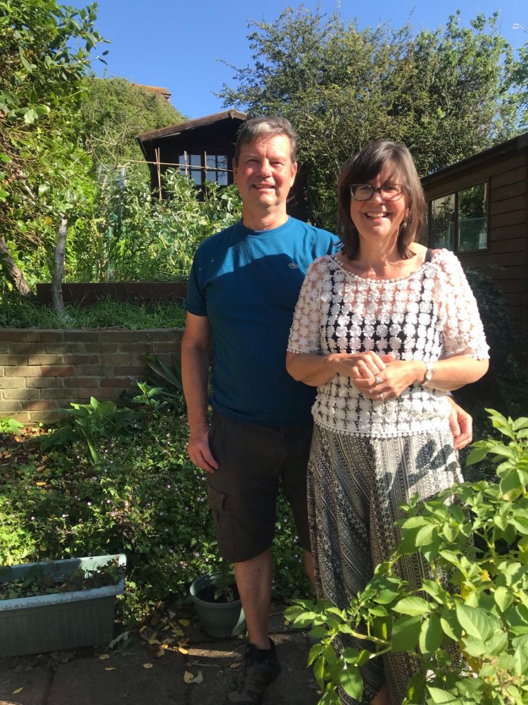 Becky and Roy in their gardenwith rows of vegetables behind
