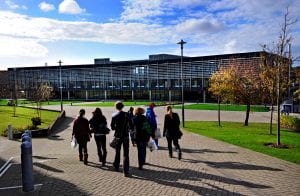 A group of students on the Falmer campus with the Checkland building in the background