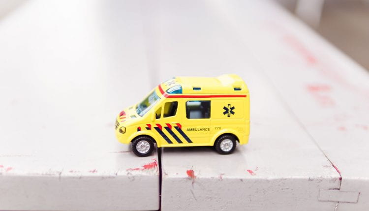 Close up of a toy ambulance on wooden tablee