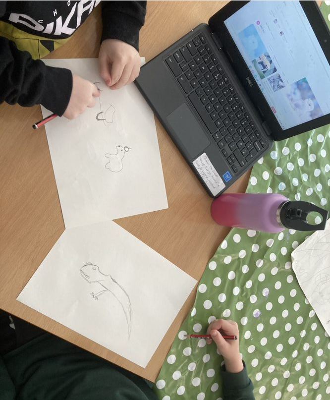 Birdseye view of child using laptop to draw 