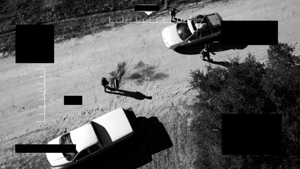 drone vision of desert scene two cars
