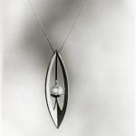 A leaf-shaped pendant design with a pearl detail