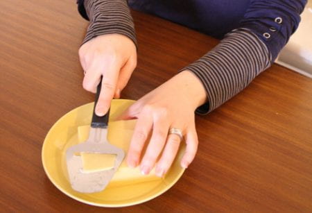 A cropped thumbnail version of a portrait of Mari Martiskainen taken by Sirpa Kutilainen, showing a yellow Arabia plate and a Fiskars cheese slicer.
