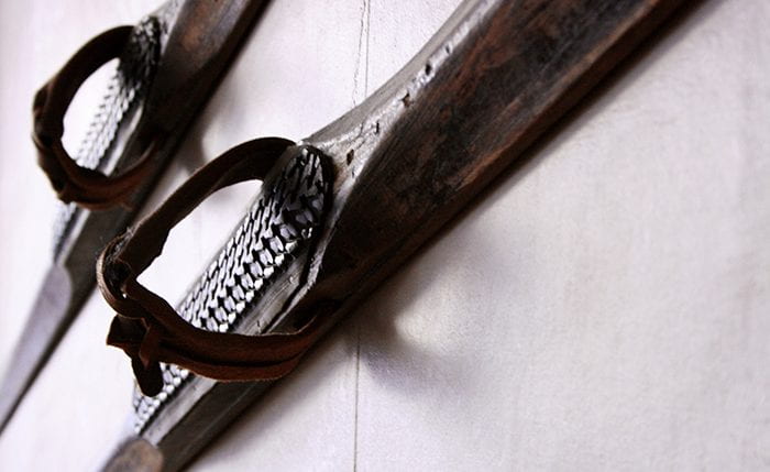 A pair of old wooden skis hanging on a wall