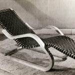 A woven, wood-framed longchair