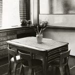 A black and white photo of a kitchen and dining room setting in Finland