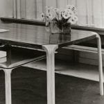 A black and white photo of an Alvar Aalto designed dining table and ceiling lamp