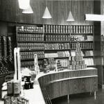 A black and white photo of a grocery shop setting with items on display