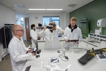 students looking at drones in a lab