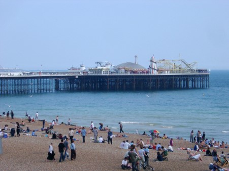 View of people on Brighton beach with the pier in the background