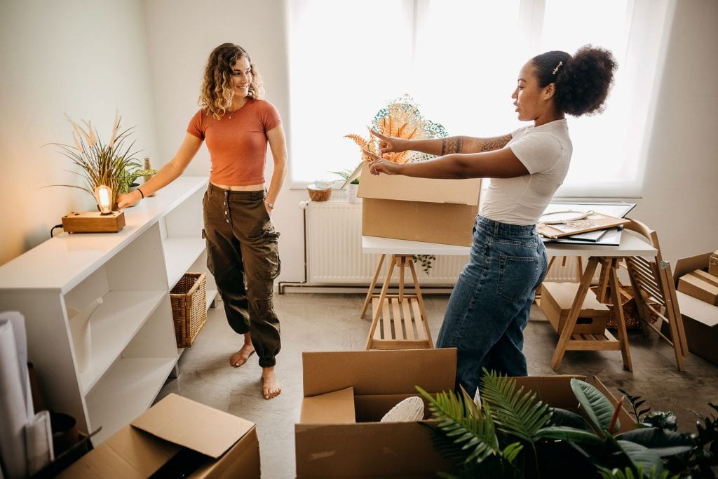 Two students moving into university room with boxes
