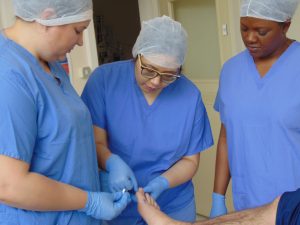 Dao Tunprasert and podiatry students doing minor surgery 
