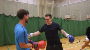 two male students wearing boxing gloves