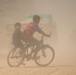 children on a bike in the haze of air pollution