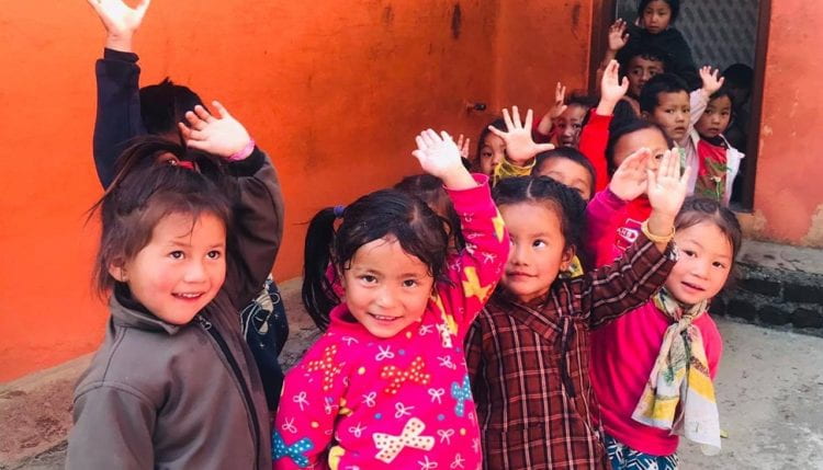 the children waving outside the school