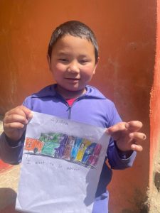 A child holding a picture showing that he would like to be a driver