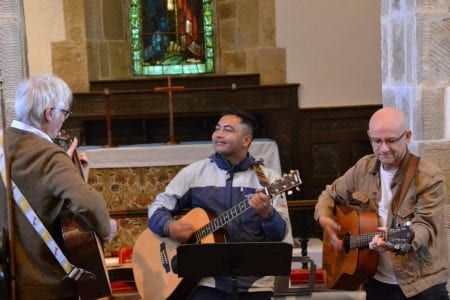 Yubaraj playing his guitar and singing in Pyecombe Church.