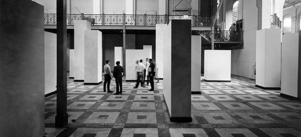 Black and white photograph of exhibition space with large free standing plinths and geometrical floor design. Smithsonian Institution, Washington DC, 1968