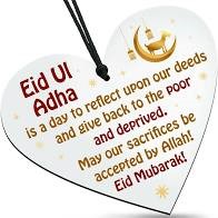 Eid al adha image showing a heart pendant with a message reading 'Eid Ul Adha' is a day to reflect upon our deeds and give back to the poor and deprived. May our sacrifieces be accepted by Ahhah! Eid Mubarak!'. A small golden goat and a crescent moon is shown on the top-right