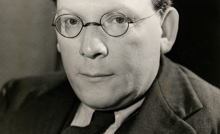Black and white portrait of Barnett Freedman wearing a suit and looking at the camera