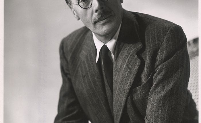 Black and white portrait of Gordon Russell in a pinstripe suit and round glasses