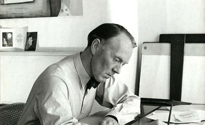 Black and white portrait of Dick Russell drawing at a table