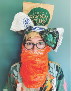 Image of person wearing glasses and carrier bags in their hair and tied around their mouth.