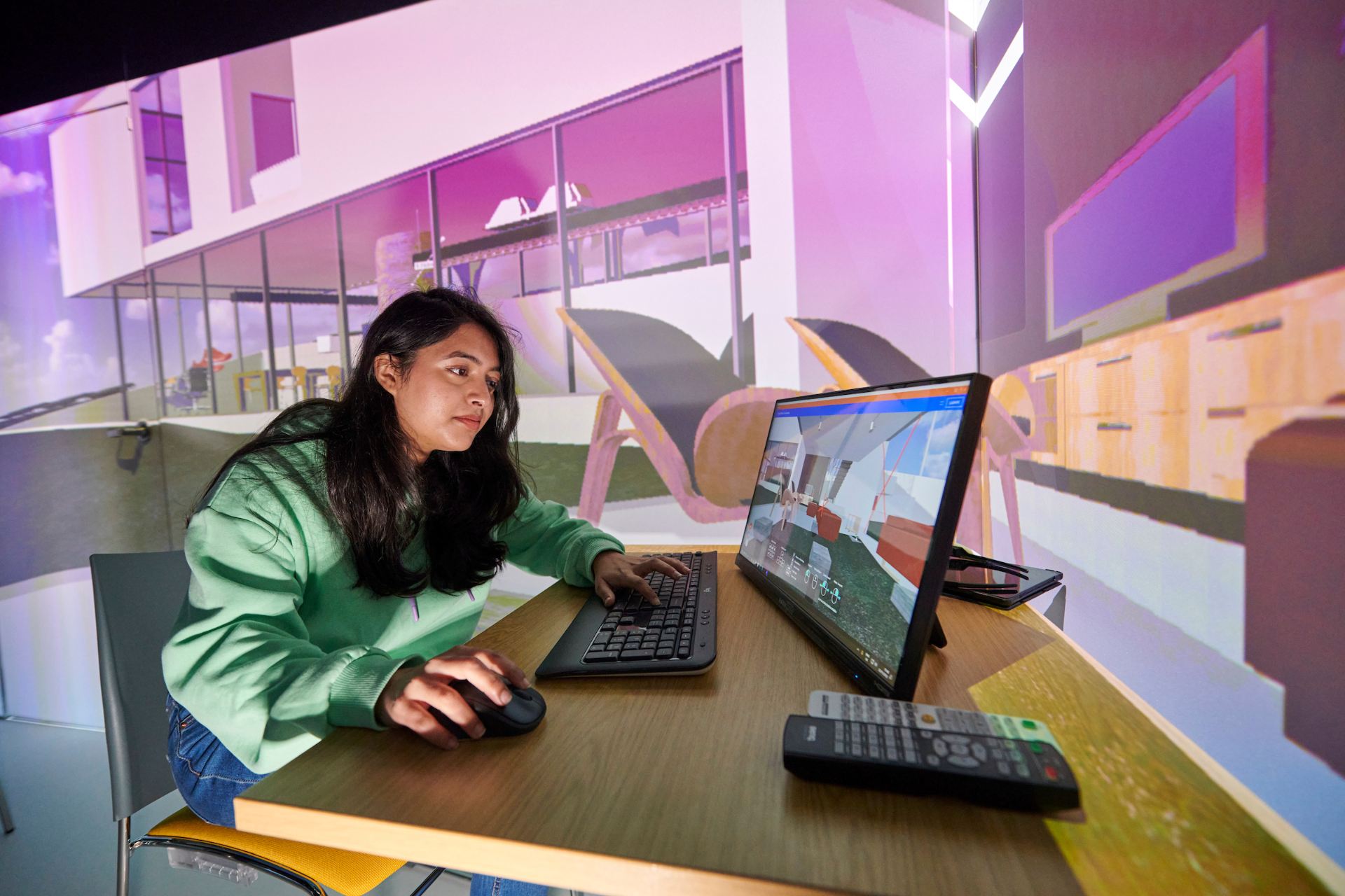 Female student using a computer with 3D imagery on the background behind her